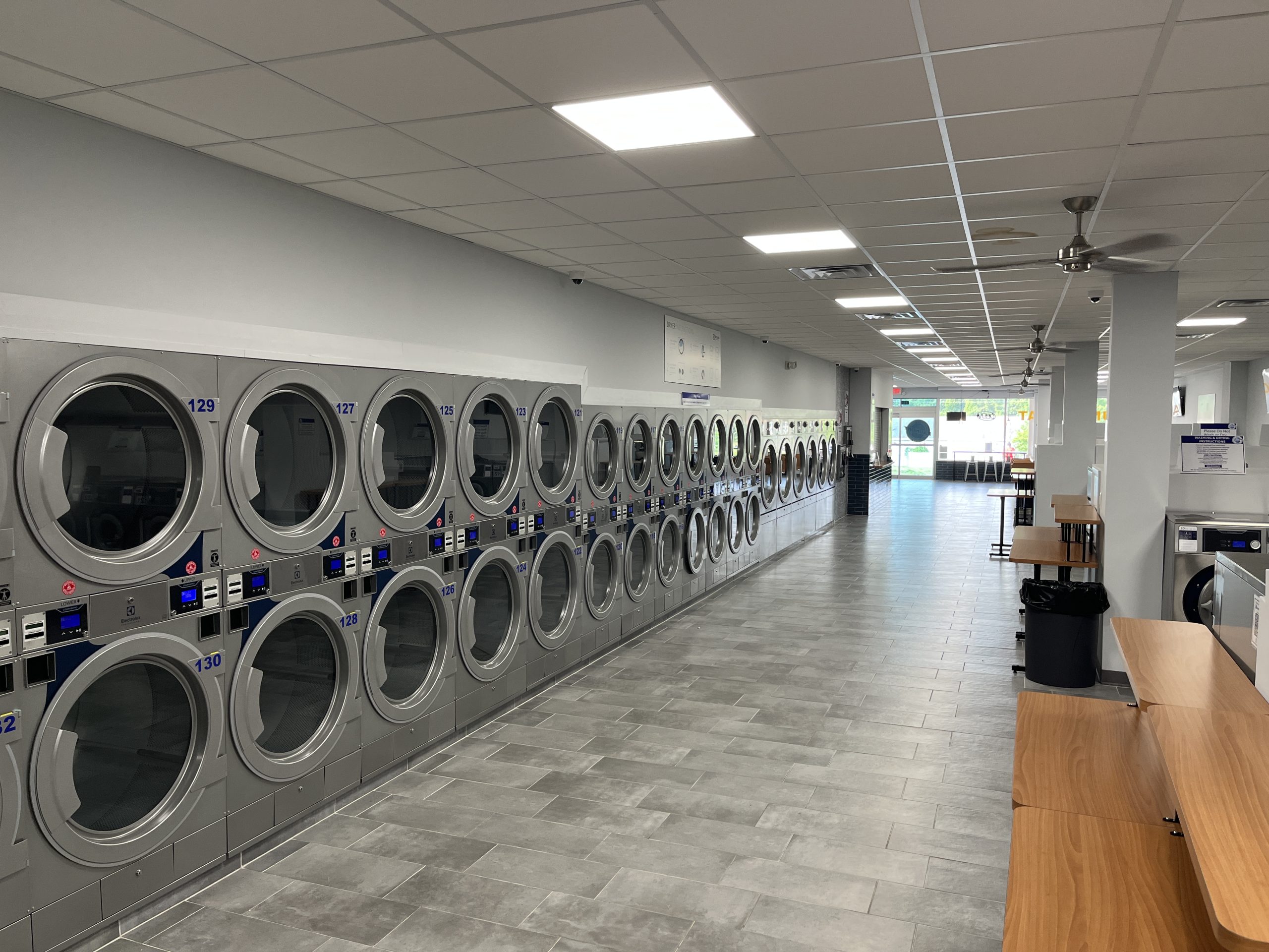 The Laundry Hub in Warminster, PA, with rows of dryers, ceiling lights and fans