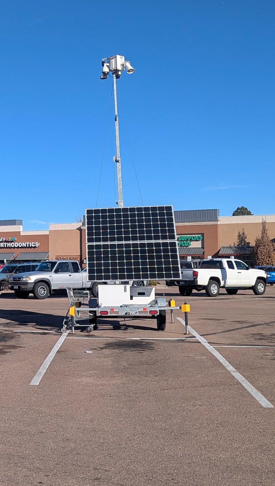 Solar-powered camera trailer in a commercial parking lot